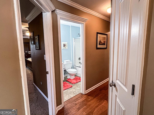 corridor with dark wood-style flooring, baseboards, and crown molding