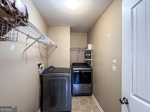 clothes washing area featuring laundry area, separate washer and dryer, and baseboards