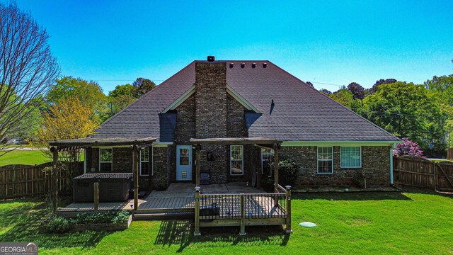 rear view of house with a chimney, a fenced backyard, a wooden deck, and a lawn