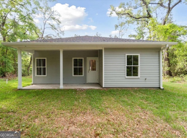 back of property featuring a patio and a lawn