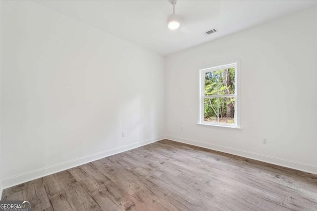 spare room with visible vents, baseboards, and wood finished floors
