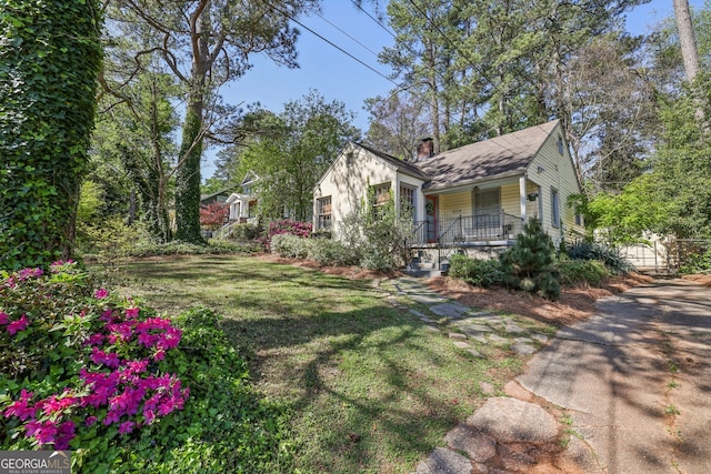 view of home's exterior featuring a yard, a porch, and a chimney