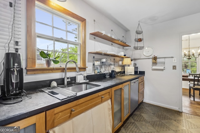 kitchen featuring a notable chandelier, a sink, dark countertops, dishwashing machine, and white microwave