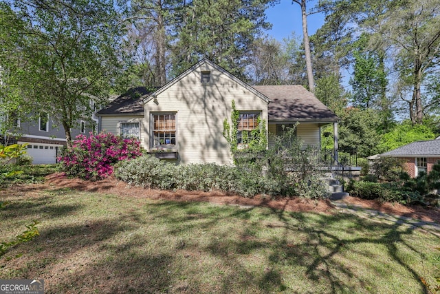 view of front of home featuring a front lawn and roof with shingles