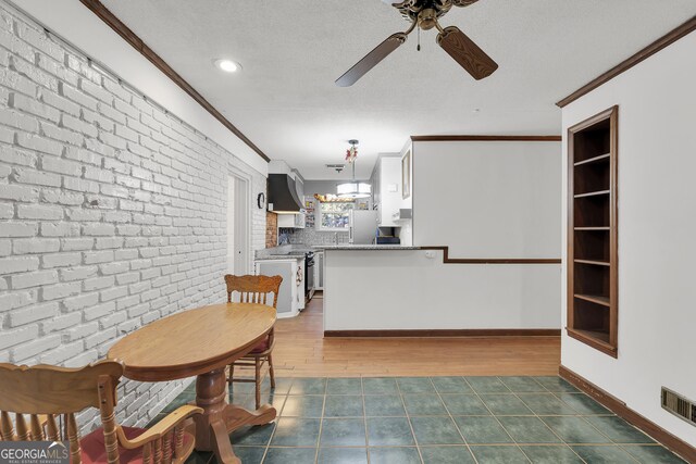 215 Cedar St, Anderson, SC 29626 - kitchen featuring freestanding refrigerator, stove, wall chimney range hood, a ceiling fan, and visible vents