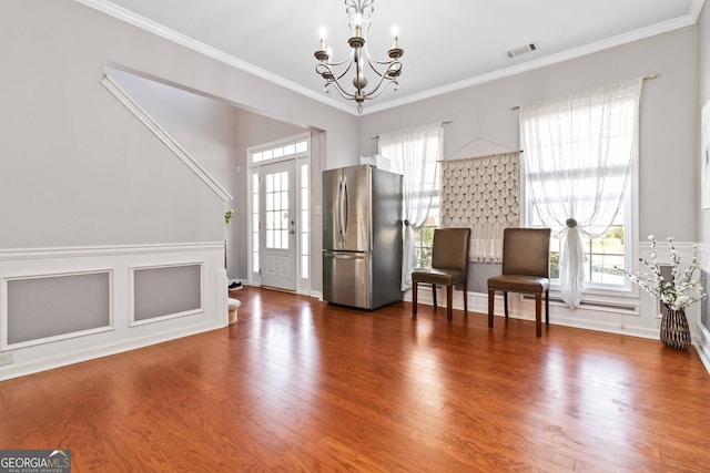 2319 White Alder Dr, Buford, GA 30519 - foyer featuring wood finished floors, a notable chandelier, ornamental molding, and visible vents