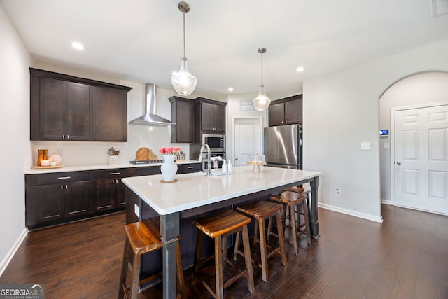 32 Winifred Way, Senoia, GA 30276 - kitchen featuring wall chimney exhaust hood, appliances with stainless steel finishes, a kitchen breakfast bar, baseboards, and light countertops