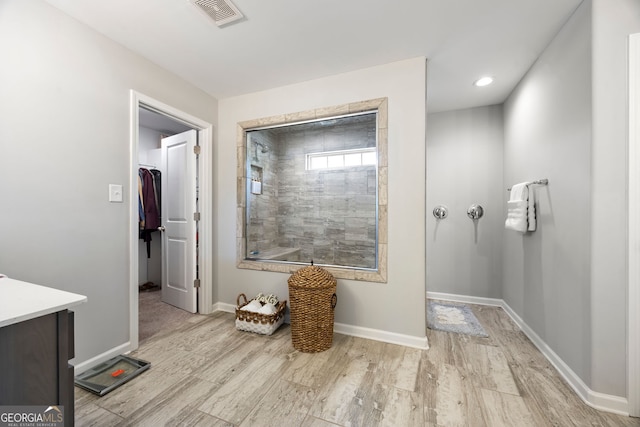 32 Winifred Way, Senoia, GA 30276 - bathroom with vanity, baseboards, wood finished floors, a walk in closet, and a tile shower