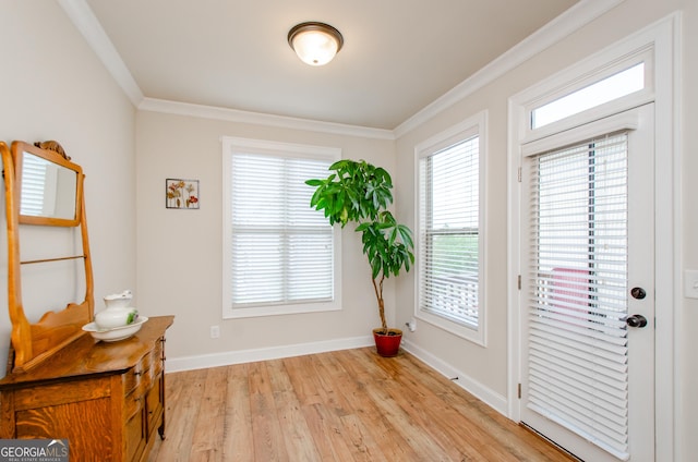 doorway with light wood-style flooring, crown molding, and baseboards
