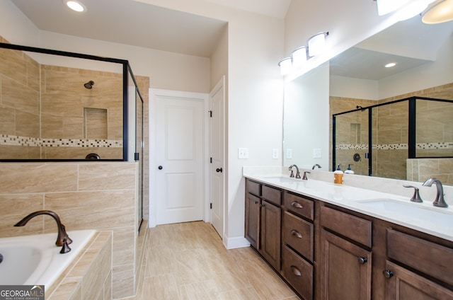 full bathroom with double vanity, recessed lighting, a shower stall, a bath, and a sink