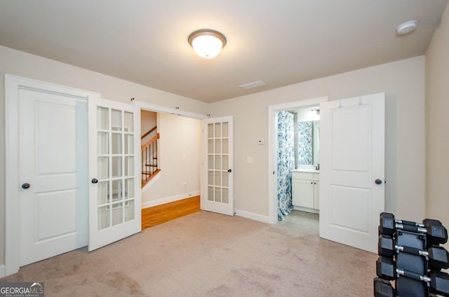 interior space with french doors, baseboards, carpet, and visible vents