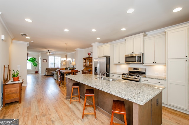 kitchen featuring stainless steel appliances, visible vents, a sink, and ornamental molding