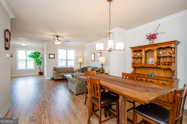 dining area featuring ornamental molding, baseboards, light wood-style floors, and ceiling fan with notable chandelier