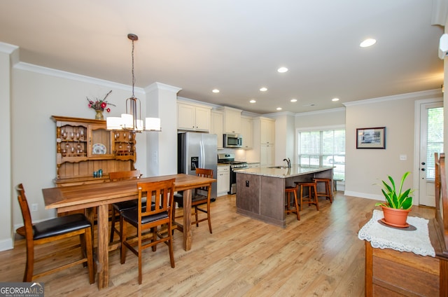 kitchen with crown molding, an island with sink, a wealth of natural light, recessed lighting, and stainless steel appliances