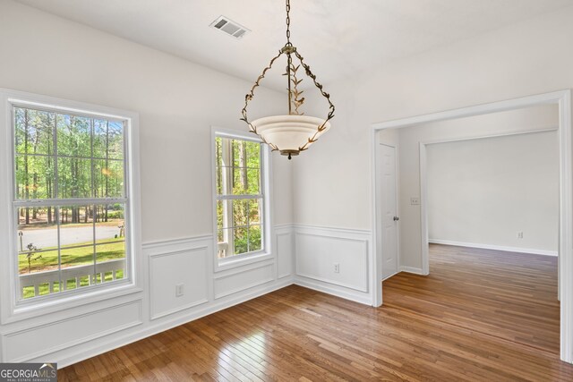 185 Cold Harbor Ct, Sharpsburg, GA 30277 - unfurnished dining area featuring an inviting chandelier, wood-type flooring, wainscoting, and visible vents