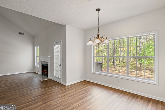185 Cold Harbor Ct, Sharpsburg, GA 30277 - unfurnished dining area featuring visible vents, baseboards, an inviting chandelier, dark wood-style flooring, and a warm lit fireplace