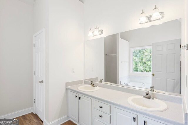 185 Cold Harbor Ct, Sharpsburg, GA 30277 - full bathroom featuring a sink, a bath, double vanity, and wood finished floors
