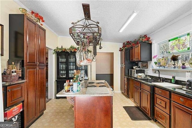 4941 N Helton Rd, Winston, GA 30187 - kitchen featuring a sink, ornamental molding, a textured ceiling, a center island with sink, and light floors