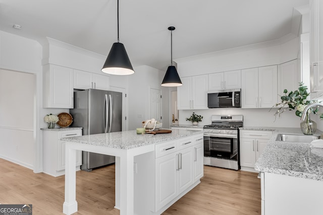 kitchen with appliances with stainless steel finishes, a sink, and white cabinetry