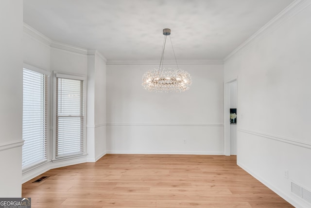 unfurnished dining area with a chandelier, light wood-type flooring, ornamental molding, and baseboards