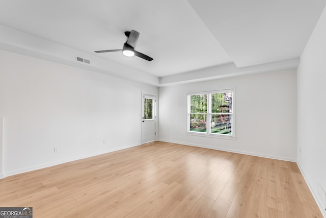empty room featuring a ceiling fan, light wood-style floors, and baseboards