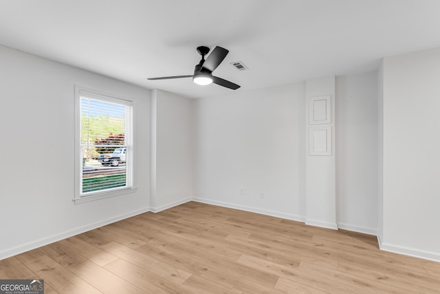 empty room featuring light wood finished floors, ceiling fan, and baseboards