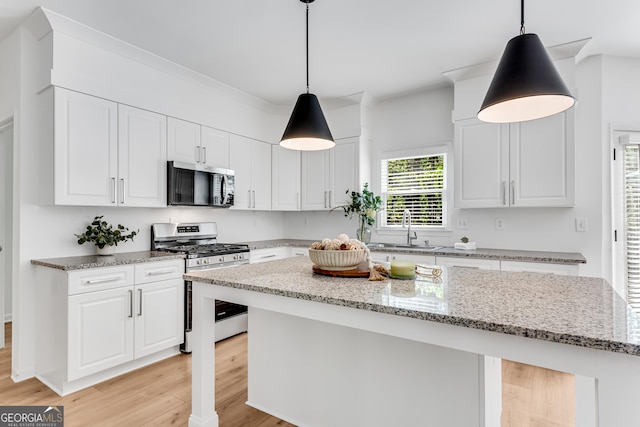 kitchen featuring stainless steel appliances, a sink, and white cabinets