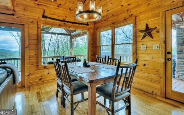 dining space featuring wood walls, light wood finished floors, and a wealth of natural light