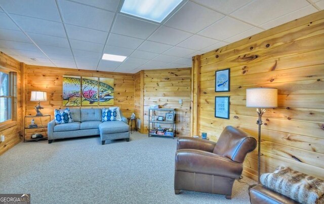 living area with wood walls and carpet flooring
