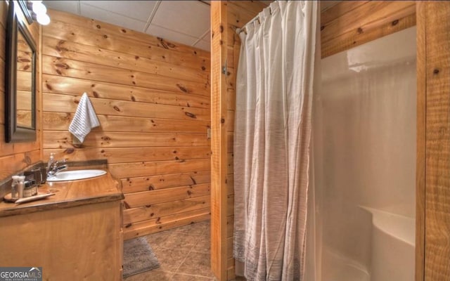 bathroom with a drop ceiling, vanity, a shower with shower curtain, and tile patterned flooring