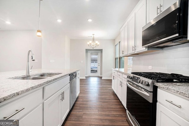 3514 Ambassador Aly, Scottdale, GA 30079 - kitchen featuring appliances with stainless steel finishes, a notable chandelier, dark wood-type flooring, decorative backsplash, and a sink