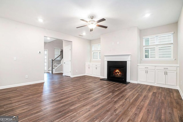 3514 Ambassador Aly, Scottdale, GA 30079 - unfurnished living room featuring baseboards, a ceiling fan, dark wood-style floors, stairway, and a glass covered fireplace