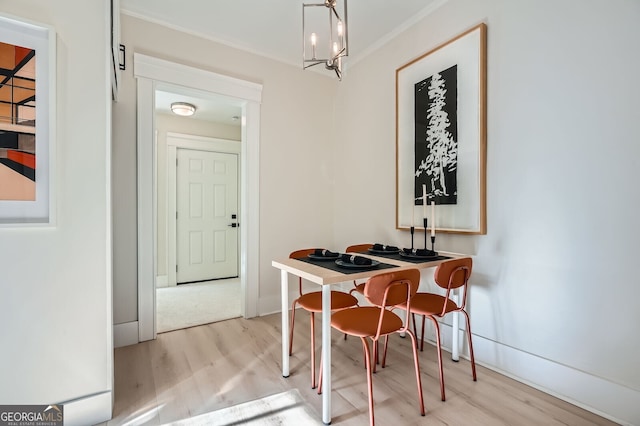dining area with a chandelier, crown molding, light wood finished floors, and baseboards