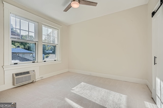 carpeted spare room with a ceiling fan, baseboards, and an AC wall unit