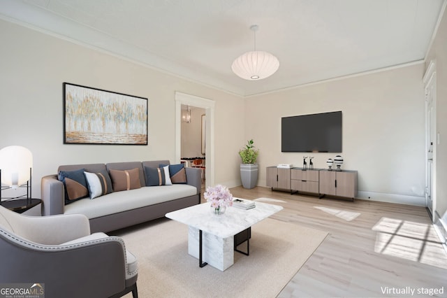 living area featuring light wood-style floors, baseboards, and ornamental molding