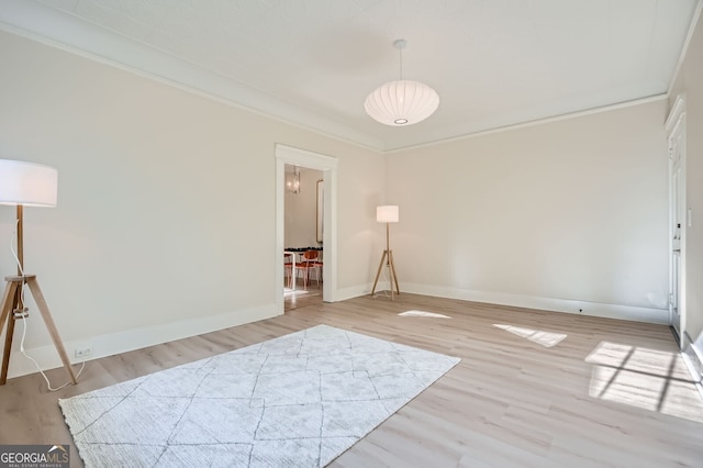 interior space with light wood finished floors, baseboards, and crown molding