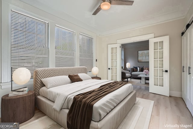 bedroom featuring french doors, ornamental molding, a ceiling fan, and light wood-style flooring