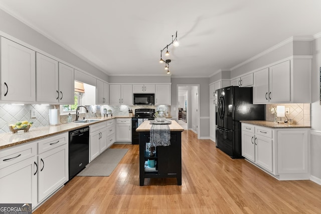 kitchen featuring a sink, white cabinetry, black appliances, and tasteful backsplash