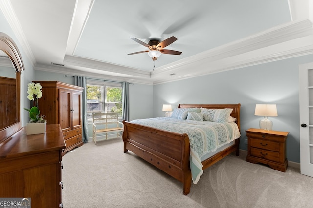 bedroom with a raised ceiling, visible vents, a ceiling fan, crown molding, and light colored carpet
