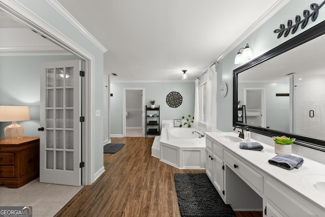 full bathroom featuring a garden tub, wood finished floors, a sink, a stall shower, and double vanity