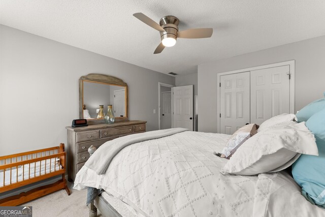 carpeted bedroom featuring a closet, ceiling fan, and visible vents