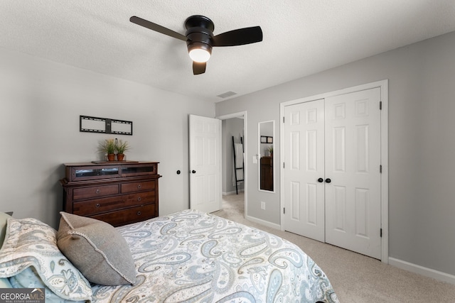 bedroom with a closet, ceiling fan, light colored carpet, baseboards, and visible vents