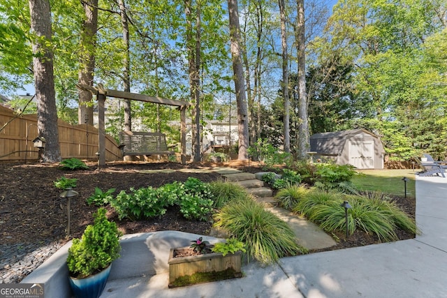 view of yard featuring fence, an outbuilding, and a storage shed