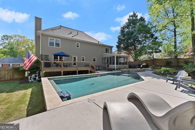 view of swimming pool featuring a fenced backyard, a yard, a patio area, a sunroom, and a deck