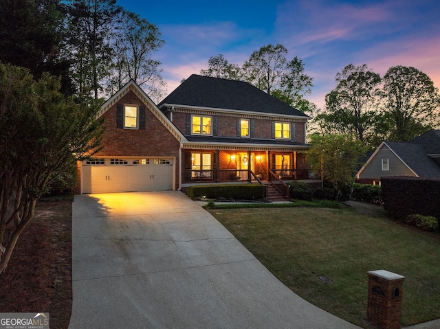 traditional home featuring a yard, driveway, a garage, and covered porch