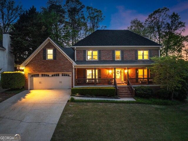 traditional-style home with concrete driveway, a porch, brick siding, a front yard, and a garage