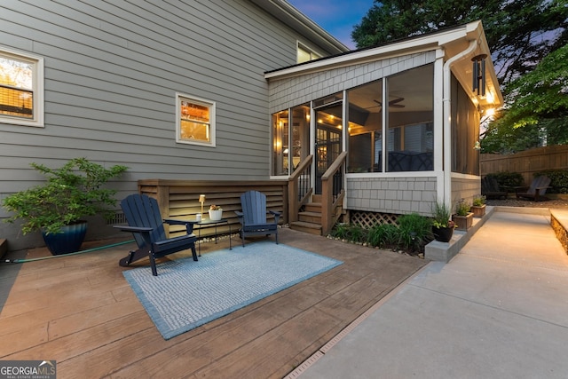 exterior space with a wooden deck, a sunroom, fence, and a patio
