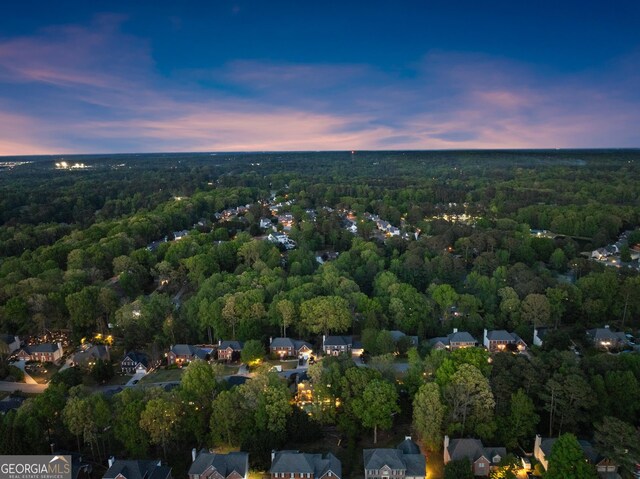 aerial view at dusk with a wooded view