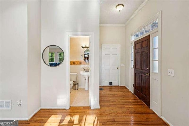 230 Oakmere Dr, Alpharetta, GA 30009 - entrance foyer featuring wood finished floors, ornamental molding, visible vents, and a wealth of natural light