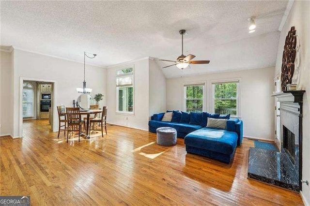 230 Oakmere Dr, Alpharetta, GA 30009 - living room featuring a textured ceiling, ceiling fan with notable chandelier, ornamental molding, and light wood-style floors
